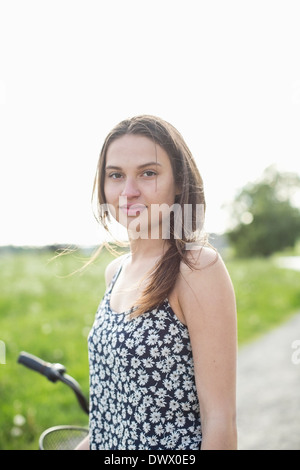 Porträt der schönen jungen Frau stehend auf Landstraße Stockfoto