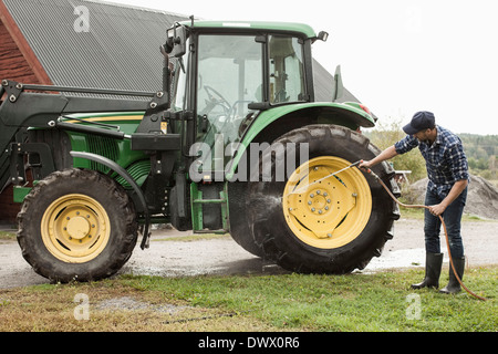 Voller Länge Landwirt Traktor Waschrad mit Schlauch in Hof Stockfoto