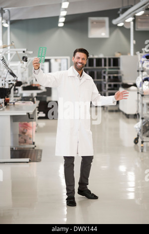 In voller Länge Portrait von glücklich Ingenieur zeigt Maschinenteil in der verarbeitenden Industrie Stockfoto