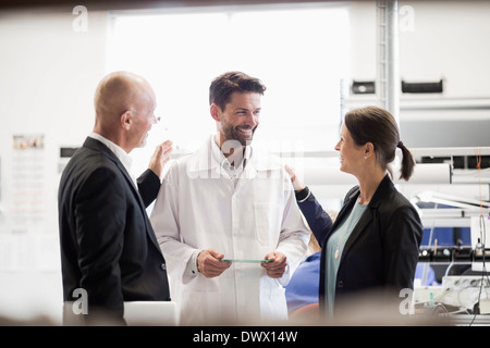 Glücklich Geschäftsleute und Ingenieur mit Platine in der Industrie Stockfoto