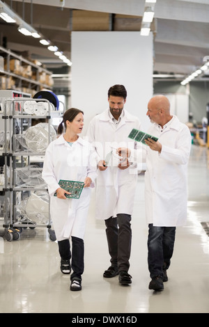 Voller Länge Ingenieure diskutieren Leiterplatten in Fabrik Stockfoto