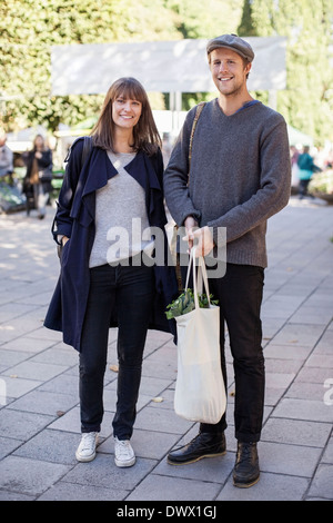 Voller Länge des Paares mit Lebensmitteln Tasche auf Bürgersteig Stockfoto