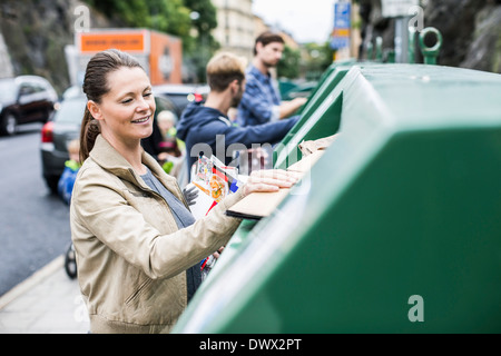 Frau und Freunde, die Inbetriebnahme, dass Wertstoffe recycling-Behälter Stockfoto