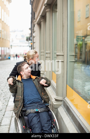 Behinderte Menschen im Rollstuhl Witwe Einkaufen mit Hausmeister Stockfoto