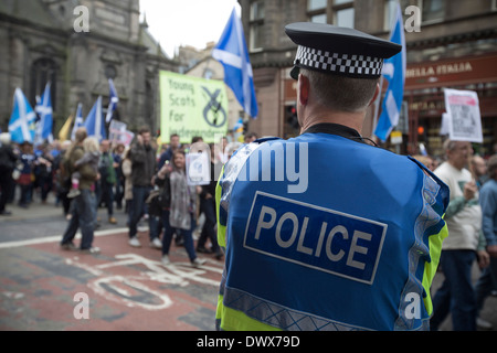 Ein Polizist beobachtet Massen marschieren hinunter North Bridge in Edinburgh während eines pro-Unabhängigkeit in Edinburgh, Schottland. Stockfoto
