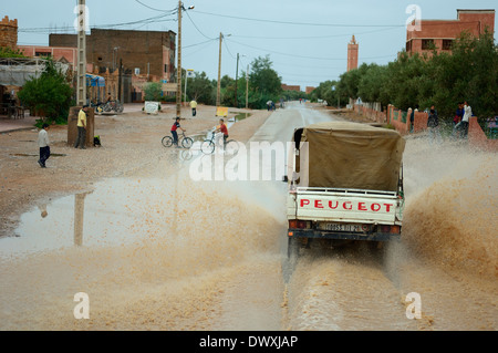 Kleine LKW-fahren durch einen großen Regen Dusche Pfütze. Marokko Stockfoto