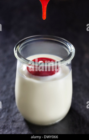 Drop von Erdbeermarmelade bereit, mit Joghurt-Topf mischen. Stockfoto