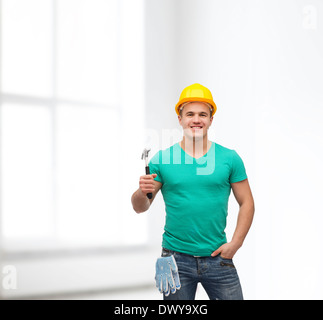 lächelnde Arbeiter im Helm mit hammer Stockfoto