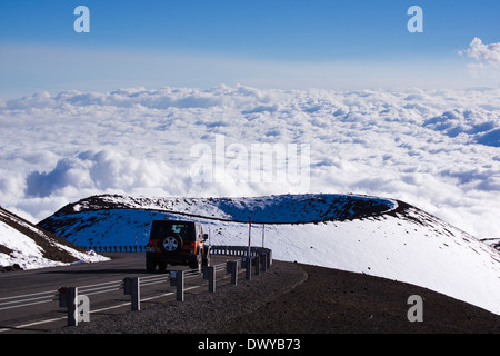 Auto auf Mauna Kea Summit Road Pu'u Hau Kea Schlackenkegel im Hintergrund. Big Island von Hawaii. Stockfoto