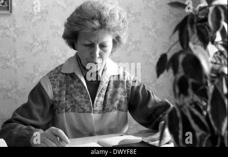 Berlin, DDR, Frau sitzt an einem Schreibtisch, blättert in einem Tagebuch Stockfoto