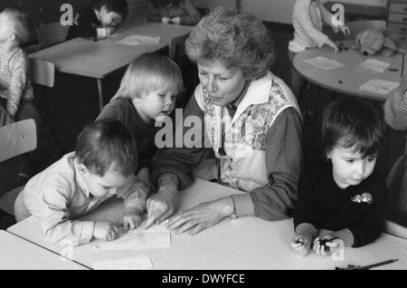 Berlin, DDR, Lehrer in einem Kindergarten zeichnen mit kleinen Kindern Stockfoto