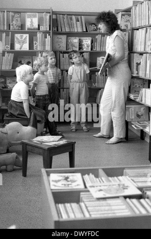 Berlin, DDR, Bibliothekar zeigt eine Gruppe von Kindern im Vorschulalter ein Buch Stockfoto