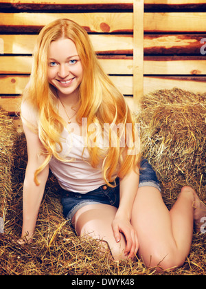 schöne Mädchen auf Heuboden am Sommertag Stockfoto