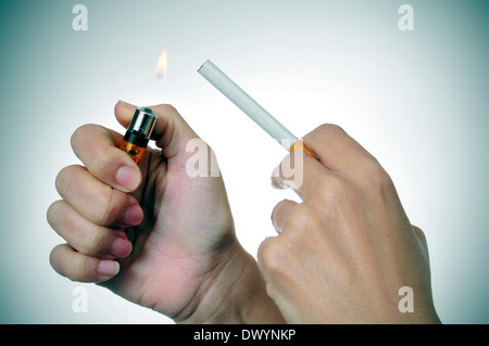 eine Frau, zündet sich eine Zigarette mit einem Feuerzeug Stockfoto