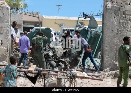 Mogadischu, Somalia. 15. März 2014. Somalische Sicherheitskräfte und Bewohner versammeln sich am Tatort die Autobombe, die den Parkplatz von Maka Almukrama Hotel in Mogadischu, Somalia, 15. März 2014 getroffen. Mindestens drei Menschen wurden verletzt, Samstag nach eine Autobombe auf dem Parkplatz eines Hotels in der somalischen Hauptstadt Mogadischu, Polizei und Zeugen sagten ging. Bildnachweis: Faisal Isse/Xinhua/Alamy Live-Nachrichten Stockfoto