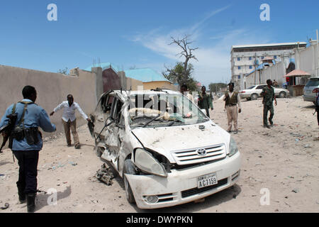 Mogadischu, Somalia. 15. März 2014. Somalische Sicherheitskräfte und Bewohner versammeln sich am Tatort die Autobombe, die den Parkplatz von Maka Almukrama Hotel in Mogadischu, Somalia, 15. März 2014 getroffen. Mindestens drei Menschen wurden verletzt, Samstag nach eine Autobombe auf dem Parkplatz eines Hotels in der somalischen Hauptstadt Mogadischu, Polizei und Zeugen sagten ging. Bildnachweis: Faisal Isse/Xinhua/Alamy Live-Nachrichten Stockfoto