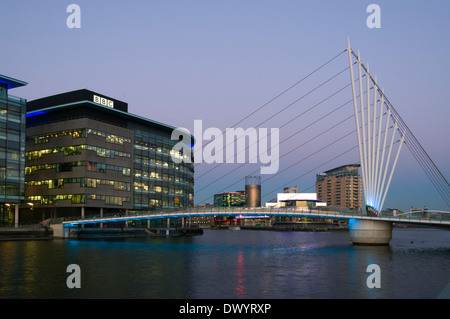 Die MediaCityUK Schaukel Fußgängerbrücke in der Abenddämmerung über den Manchester Ship Canal bei Salford Quays, Manchester, England, UK Stockfoto