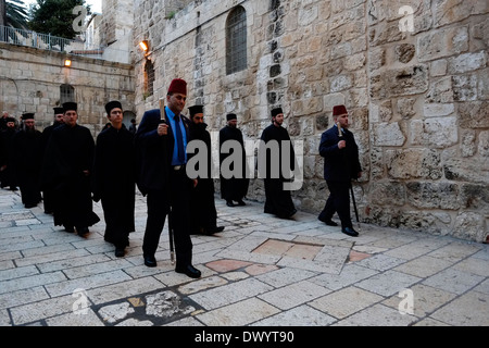 Muslimische Konsularwachen, auch bekannt als „Kawas“ mit roten Tarbooshhüten, führen Priester und Mitglieder der griechisch-orthodoxen Kirche zur täglichen Prozession in der Kirche des heiligen Grabes in der Altstadt des christlichen Viertels Ost-Jerusalem Israel Stockfoto