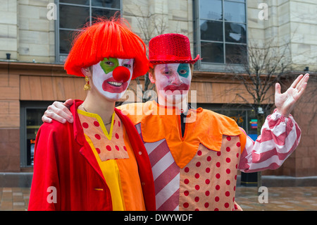 Zwei Studenten aus Glasgow RADA verkleidet als Clowns, die Durchführung als Straßenmusikant und waren Stockfoto