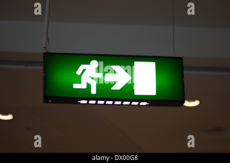 Rettungszeichen mit weißer, weißer Pfeil und weiße Tür auf grünem Hintergrund. Stockfoto