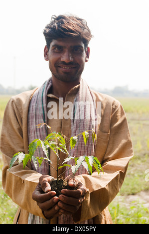 1 indische Bauern stehen mit Pflanze Stockfoto