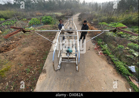 Miluo, China. 16 März 2014 (Xinhua)--Bauer Li Housheng (L) führt den Flug von seinem Helicopeter an einen Nachbarn in Ganzhou Dorf der Baitang Township im Miluo Stadt, Zentral-China Provinz Hunan, 14. März 2014. Bauer Li Housheng, 52, hat angefangen, seine Twin-Rotor Helicopeter seit August 2013. Die Helicopeter hat einen Motor verpflanzt aus einem landwirtschaftlichen Motorrad mit Skeletten von Winkel-Eisen und Edelstahl Rohre gemacht. Jeder Rotor ist einfach eine Verschweißung vier Stahlplatten. Der Hubschrauber-Kontrollsystem einschließlich Gas, Kupplung und Joystick stammt aus Stockfoto