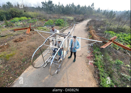 Miluo, China. 16 März 2014 (Xinhua)--Farmer Li Housheng (C) stellt seinen Flugplan, wie er in seinem Helicopeter in Ganzhou Dorf der Baitang Township im Miluo Stadt, Zentral-China Provinz Hunan, 14. März 2014 sitzt. Bauer Li Housheng, 52, hat angefangen, seine Twin-Rotor Helicopeter seit August 2013. Die Helicopeter hat einen Motor verpflanzt aus einem landwirtschaftlichen Motorrad mit Skeletten von Winkel-Eisen und Edelstahl Rohre gemacht. Jeder Rotor ist einfach eine Verschweißung vier Stahlplatten. Der Hubschrauber-Kontrollsystem einschließlich Gas, Kupplung und Joystick stammt aus einer motorc Stockfoto