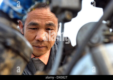 Miluo, China. 16 März 2014 (Xinhua)--Bauer Li Housheng untersucht den Motor seine Helicopeter in Ganzhou Dorf der Baitang Township im Miluo Stadt, Zentral-China Provinz Hunan, 14. März 2014. Bauer Li Housheng, 52, hat angefangen, seine Twin-Rotor Helicopeter seit August 2013. Die Helicopeter hat einen Motor verpflanzt aus einem landwirtschaftlichen Motorrad mit Skeletten von Winkel-Eisen und Edelstahl Rohre gemacht. Jeder Rotor ist einfach eine Verschweißung vier Stahlplatten. Der Hubschrauber-Kontrollsystem einschließlich Gas, Kupplung und Joystick stammt aus einem Motorrad. Der Hubschrauber-c Stockfoto