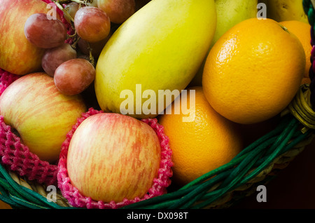 Obst-Geschenk-Korb mit Trauben, Äpfel, Mangos und Orangen gefüllt Stockfoto