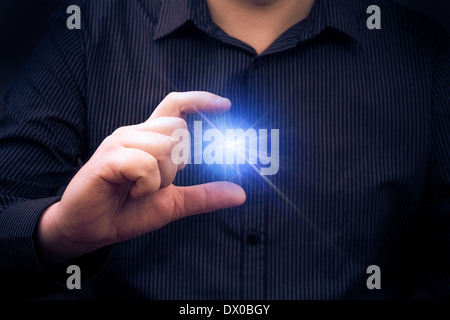 Auf mysteriöse Weise emittierende macht in der Hand eines Mannes Stockfoto