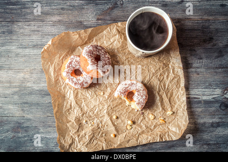 Heißer Kaffee und Donuts in das Papier gegeben Stockfoto