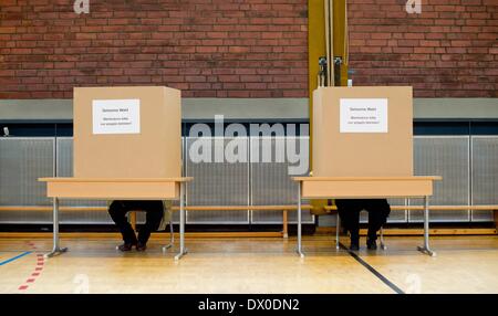 München, Deutschland. 16. März 2014. Ein Mann und eine Frau geben ihre Stimme in einem Wahllokal in München, Deutschland, 16. März 2014. Menschen in Bayern werden gebeten, ihre Stimme bei den Kommunalwahlen am 16. März abgeben. Foto: Sven Hoppe/Dpa/Alamy Live News Stockfoto