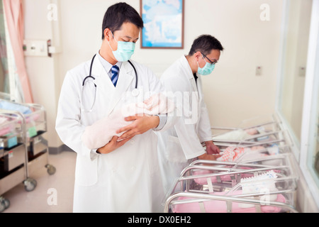 Frauenarzt Arzt mit einem gefälschten neugeborenes Baby im Krankenhaus Stockfoto