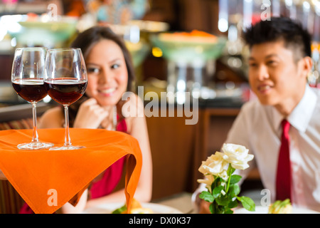 Kellner oder Steward für Mann und Frau oder paar roten Wein in Gläsern auf einem Tablett in einem ausgefallenen Restaurant oder Hotel Stockfoto