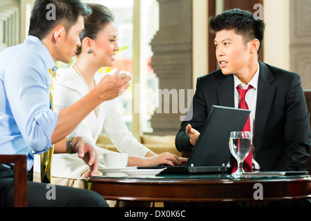 Drei asiatische chinesische Büro Menschen oder Geschäftsleute und Geschäftsfrau, die mit einem Business-Meeting in einer Hotel-lobby Stockfoto