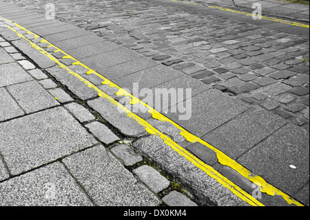 Doppelte gelbe Linien auf einer gepflasterten Straße in England Stockfoto