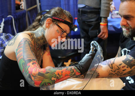 New York, New York, USA. 8. März 2014. 17. Jahrestagung der New-York-City-Tattoo statt im Roseland Ballroom in Manhattan. Tattoo-Künstler aus der ganzen Welt kommen zu diesem Übereinkommen für Auszeichnungen konkurrieren und zeigen es, Fähigkeiten als Künstler. © 2014 Hannah Wolf aus San Francisco Ca. funktioniert auf Casey aus Brooklyn © Bruce Cotler/Globe Photos/ZUMAPRESS.com/Alamy Live News Stockfoto