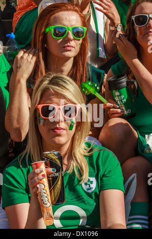 London, Vereinigtes Königreich . März 2014. Junge Frauen genießen die Sonne in London während der jährlichen St. Patrick's Day Parade. Stockfoto