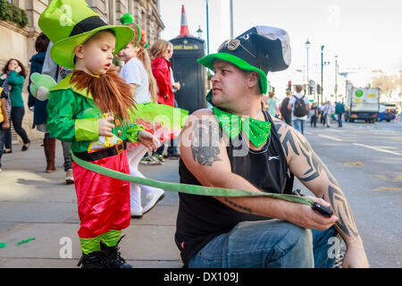 Kleiner Junge gekleidet wie ein Kobold mit seinem Vater am St. Patricks Day Parade, London, UK Stockfoto