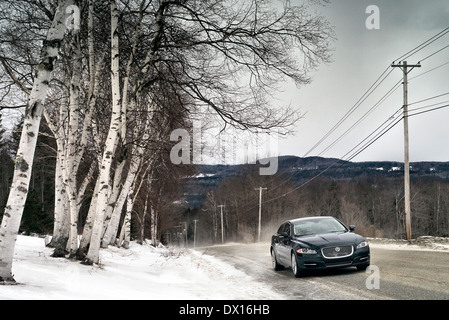 Jaguar XJ AWD fahren auf einer Bergstraße im Winter in der Nähe von Skigebiet Stowe Vermont New England USA Stockfoto