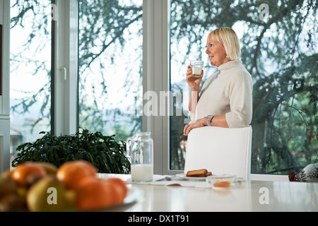 Porträt von senior kaukasischen Frau trinken frischen Milch zum Frühstück zu Hause Stockfoto