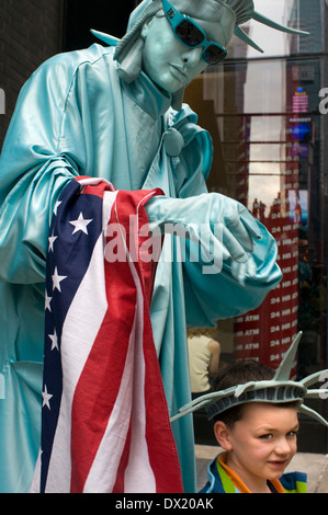Abgebildet ist eine menschliche Statue in New Yorker Freiheitsstatue gekleidet mit einem Kind in der Nähe von Times Square. Wenn man gute Fotos des Times Square, Stockfoto