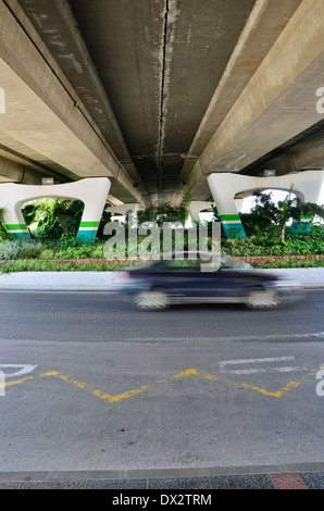 Kreisverkehr unter einer Autobahnbrücke mit Vegetation, Spanien. Stockfoto