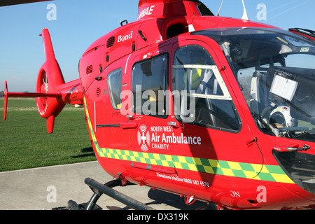 eines der drei North West Ambulanzflugzeuge, eine rote Eurocopter EC135 Hubschrauber Flugzeuge Bond Air Services Stockfoto