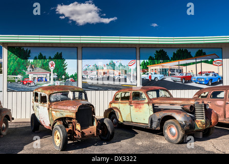 Alte, verrostete Autos zu verkaufen, Wandbilder hinter an der Tankstelle, im Delta, Colorado, USA Stockfoto