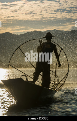 INLE-See, MYANMAR - ca. Dezember 2013: Fischer mit typischen Net und Boot in der Inle See, Myanmar Stockfoto