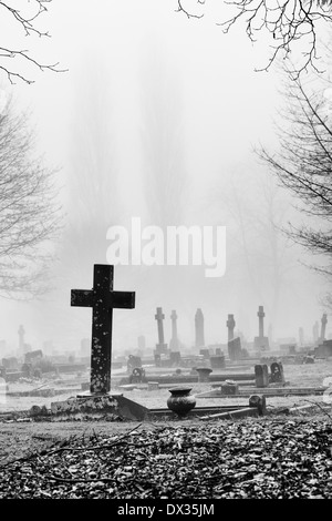 Kreuz Grabstein in den Nebel im Friedhof von Banbury, Oxfordshire, England. Monochrom Stockfoto