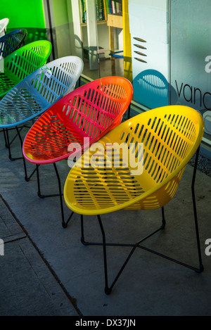 bunte Runde Kunststoff-Stühle in einer Reihe Stockfoto