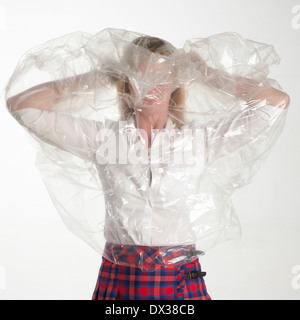 Frau auf einem Kunststoff durchschauen Poncho mac Stockfoto