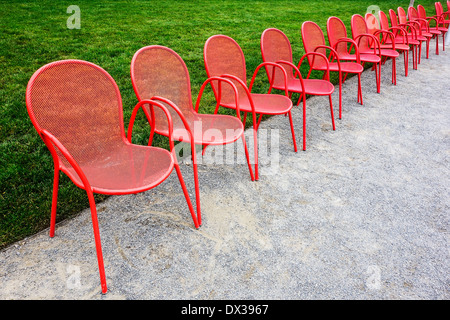 Rote Stühle Metall und grasgrün Stockfoto